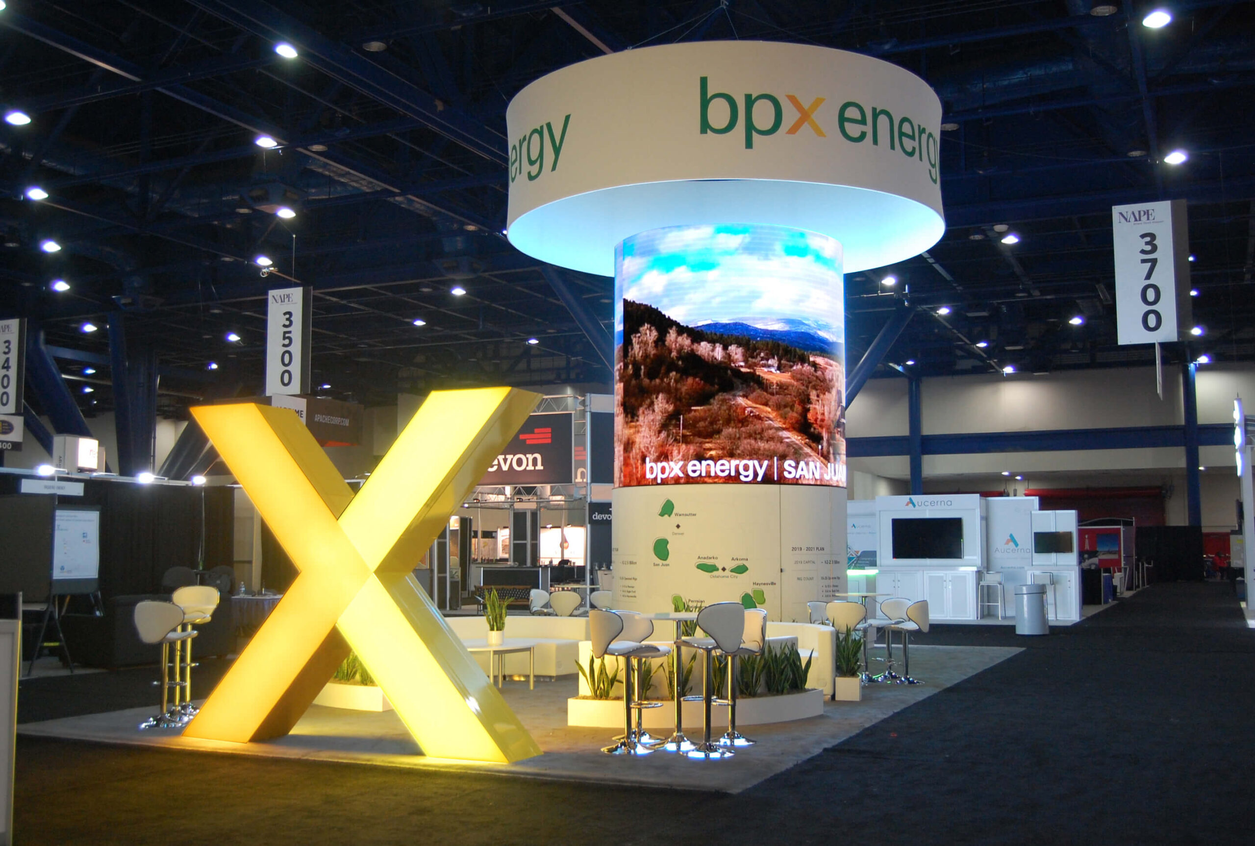 Large, 3D backlit, yellow X in front of a custom circular tower with rounded LED tiles proudly introduces BPX Energy brand.