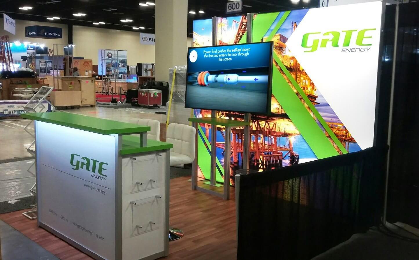 Branded, 10’ backlit fabric graphic with custom fabricated counter and wall monitor for energy trade shows and conventions.