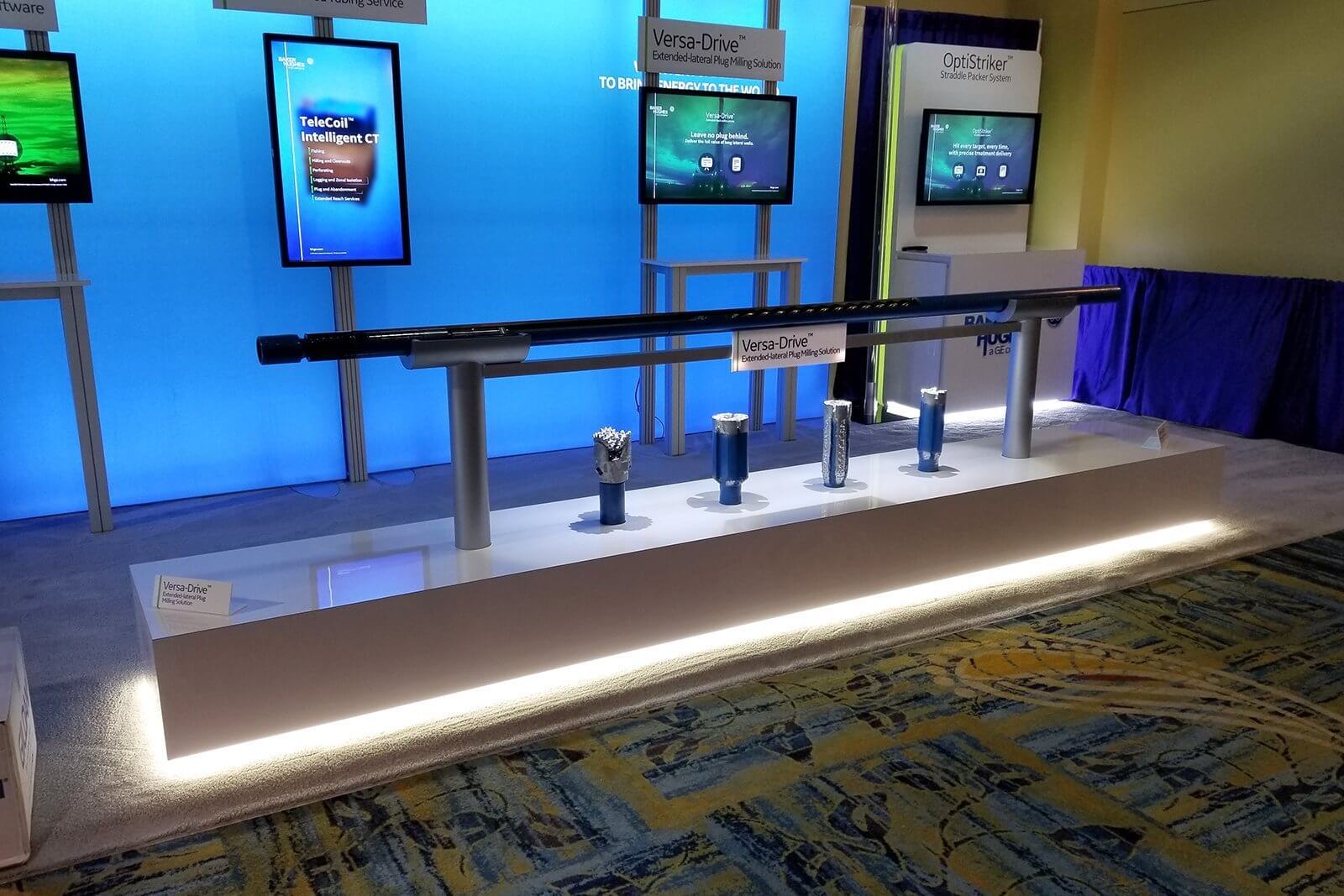 Blue, back-lit wall displays touchscreens and drill bits to facilitate conversations with staff and trade show attendees.