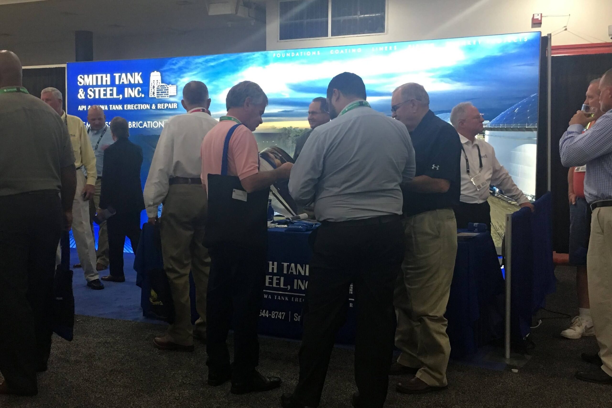 A crowd gathers in a 10 x 20 exhibit booth with 20’ backlit graphic mural at the ILTA conference and trade show in Houston