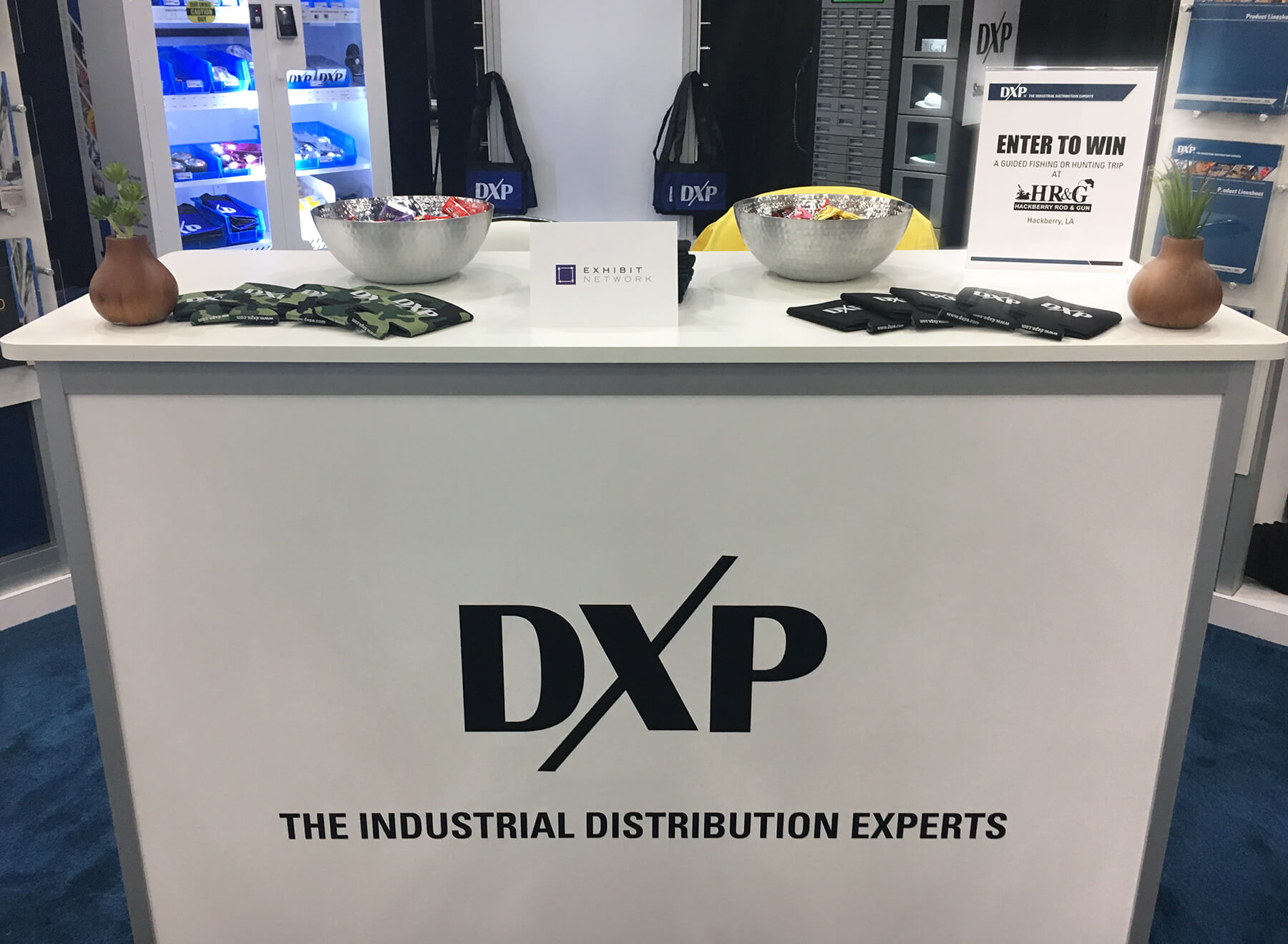 Trade show podium with exhibitor promotional items, bowls of candy for expo attendees and signage promoting a raffle giveaway