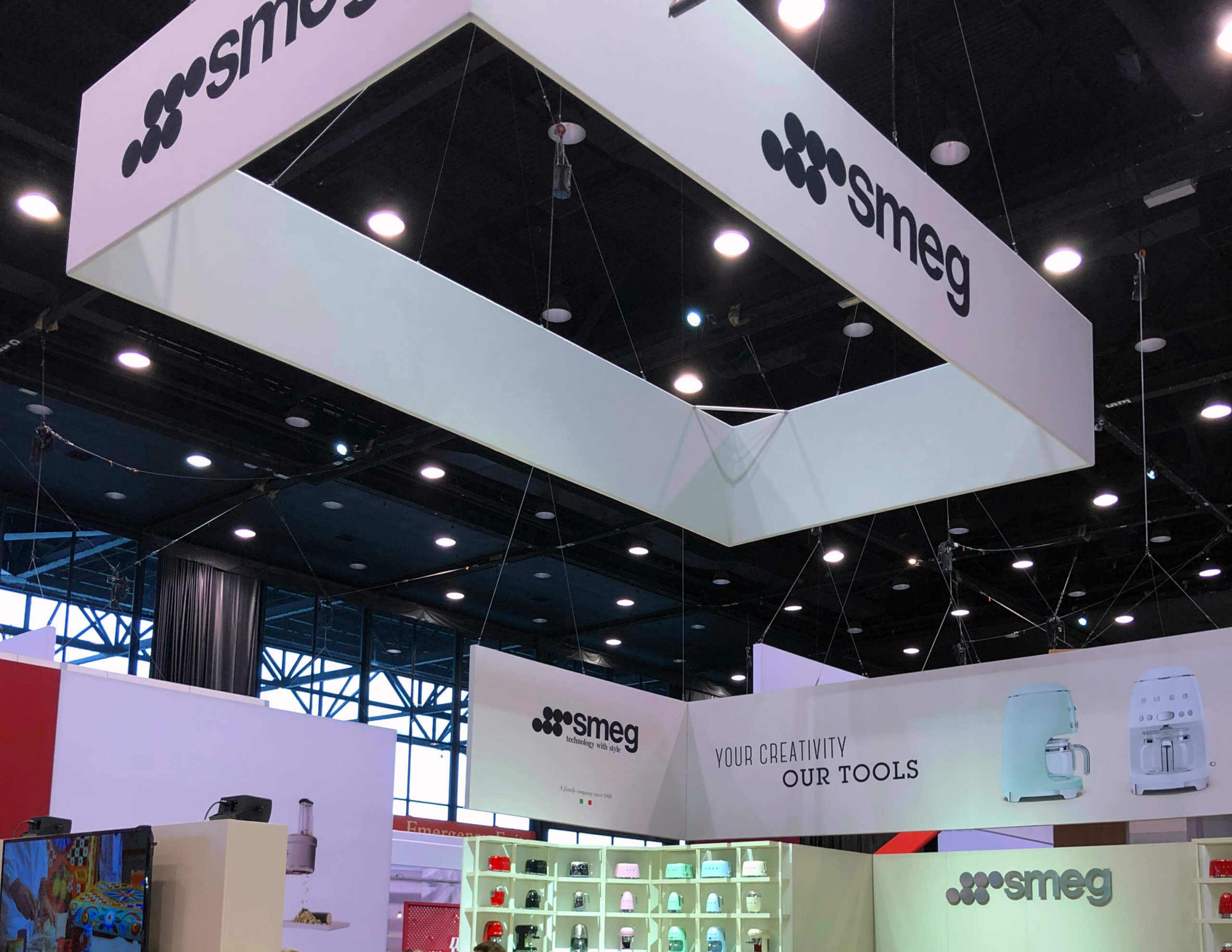 74’ x 9.5’ rectangle, white overhead sign with SMEG logo. Other signs were square, L-shaped, and rectangular with graphics.