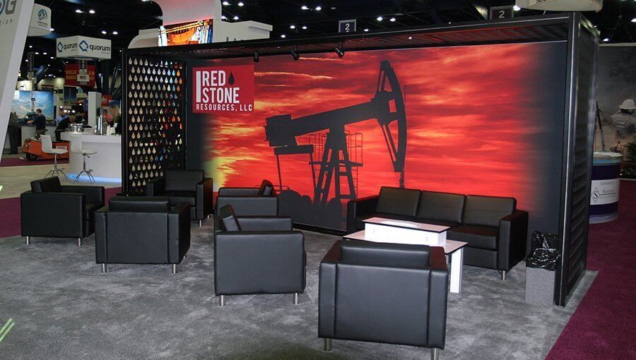 Large-format graphics of a black drill with deep red sunset is the perfect backdrop for a black leather seating area at NAPE.