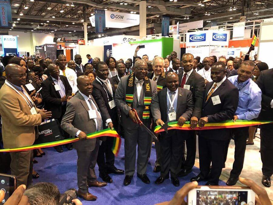 A ribbon-cutting ceremony with green, yellow, and red stripes of the Ghana flag at the Ghana Pavillion at OTC